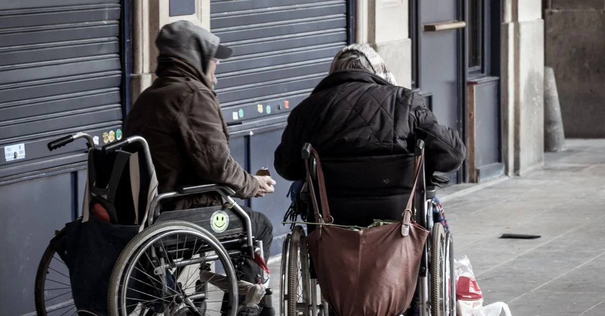 Deux seniors en fauteuils roulants socialisant à l'extérieur en tenue d'hiver.