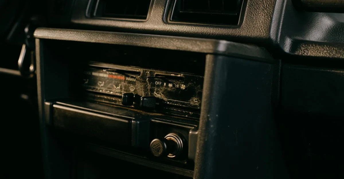 Gros plan du tableau de bord d'une vieille voiture avec un système de radio vintage.