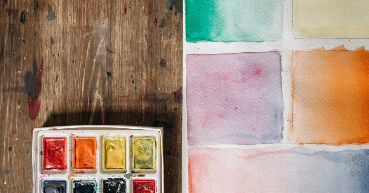 Une palette de aquarelle avec divers échantillons de couleurs sur papier, idéale pour des projets artistiques.